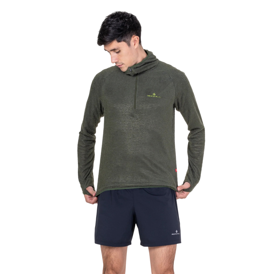 Up & Running model wearing a Ronhill olive green Primaloft running hoodie with a quarter zip and thumb holes