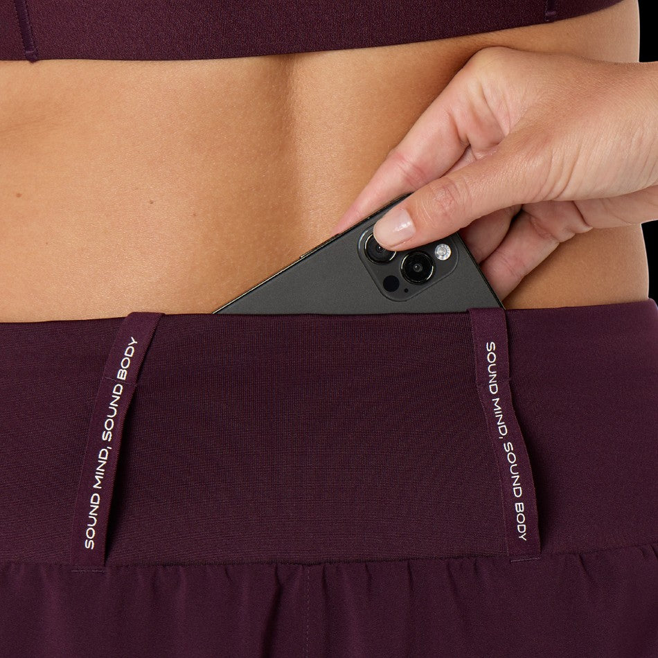 Up & Running ASICS women's dark aubergine running shorts featuring a convenient back phone storage pocket