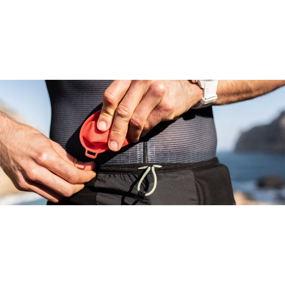 Up & Running Compressport red collapsible trail running cup being stored in a running vest pocket