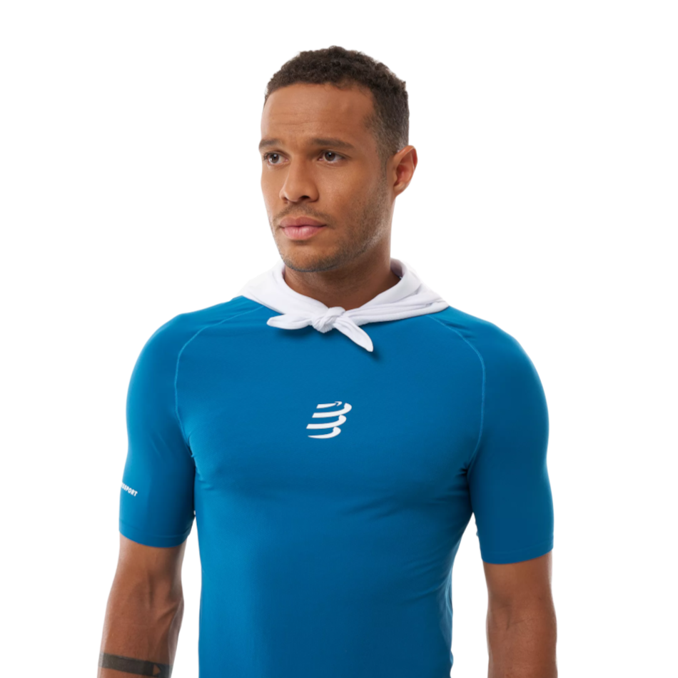 Up & Running Compressport white cooling bandana worn around the neck by a male athlete in a blue technical shirt