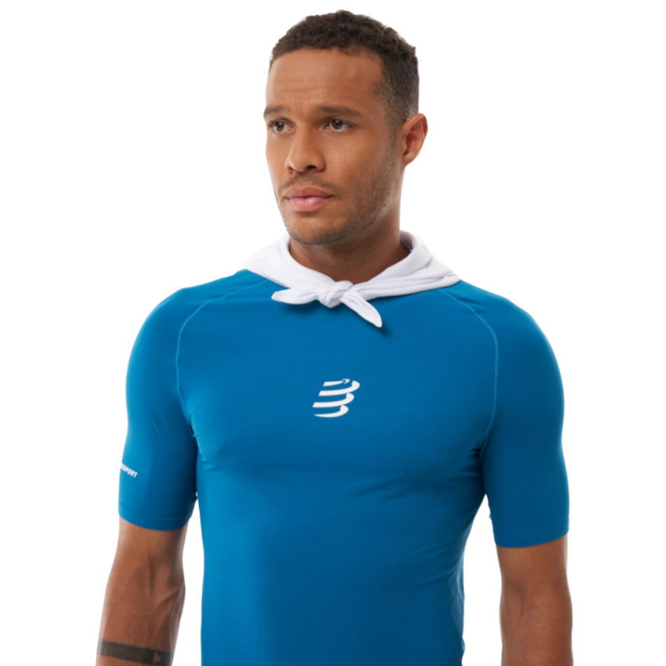 Up & Running Compressport white cooling bandana worn around the neck by a male athlete in a blue technical shirt