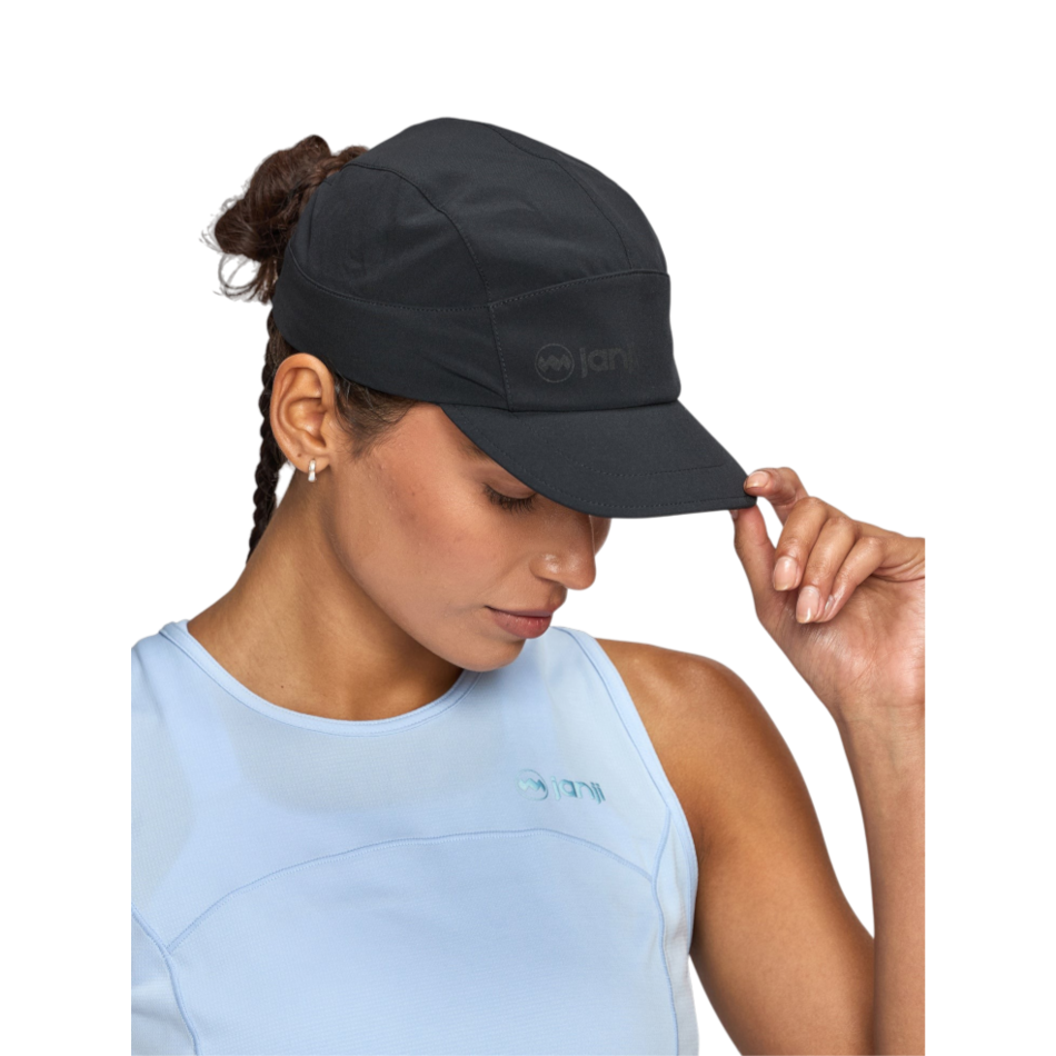 Up & Running Janji AFO Hyperlight running cap in midnight black worn by a woman against a white background