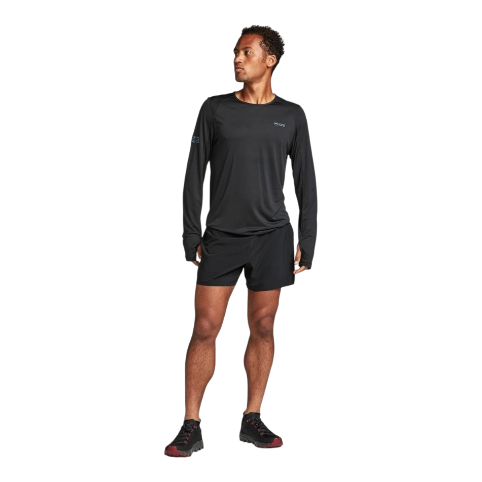 Up & Running model wearing a black Janji Men's Run All Day long sleeve performance shirt with matching shorts